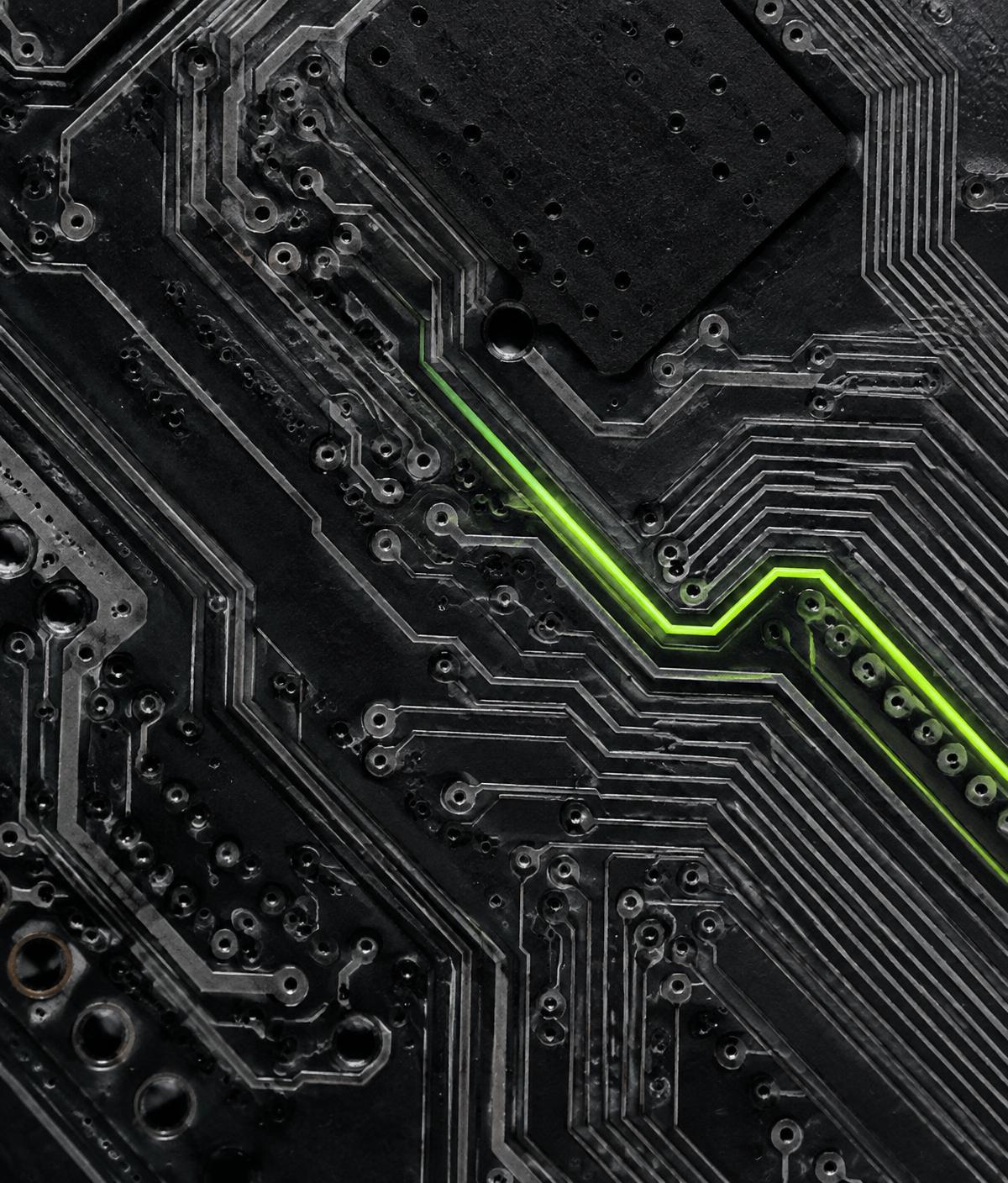 Dark circuit board with a glowing lime trace, representing custom-built logic
